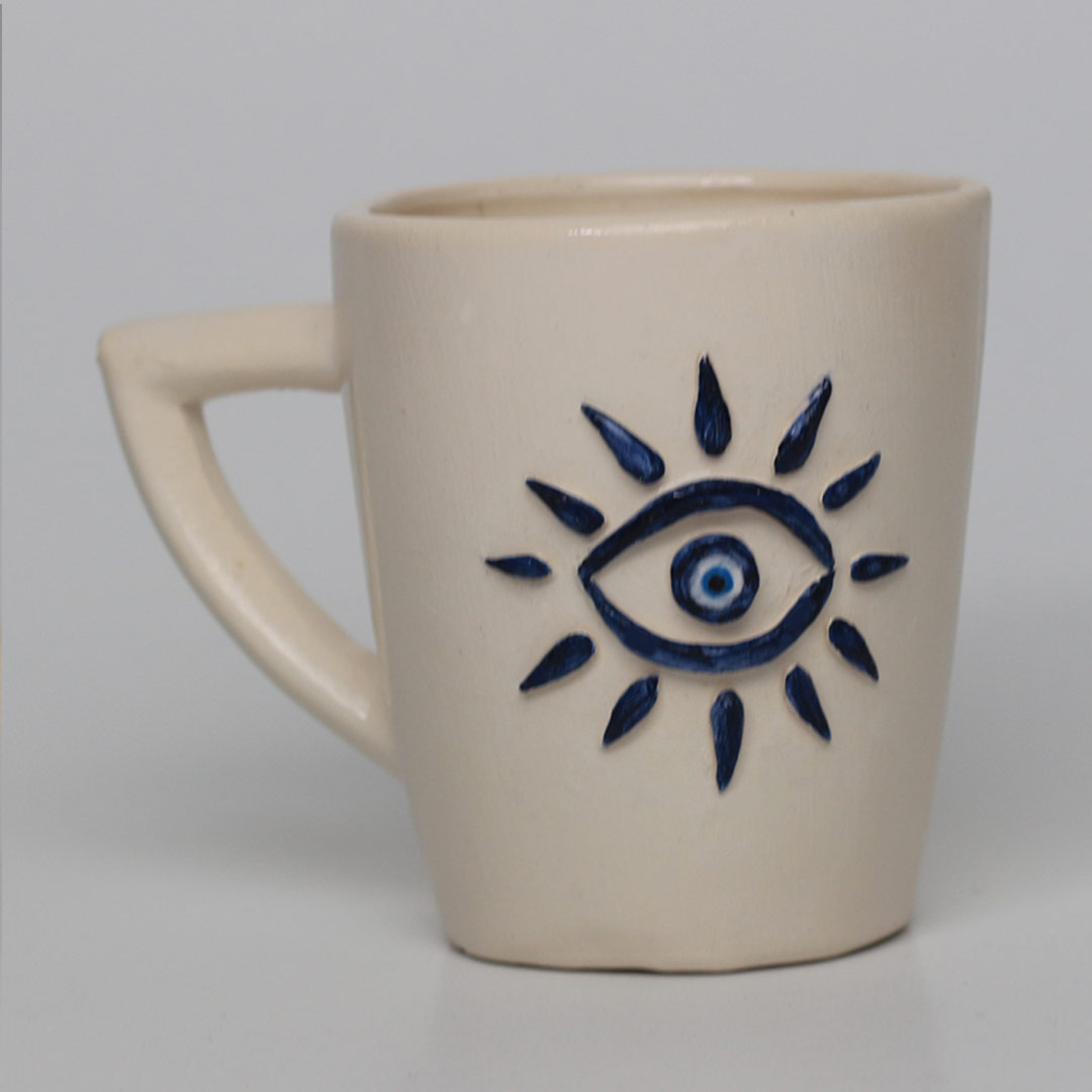 Ceramic conical-shaped mug with raised eye motif grip