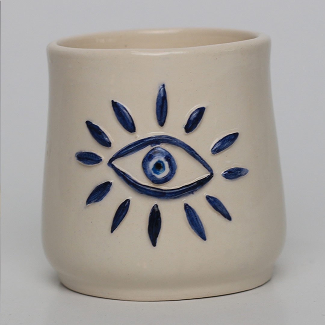 Ceramic handleless mug with raised eye motif