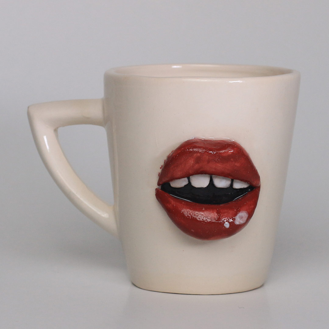 Ceramic mug with open lips design in relief