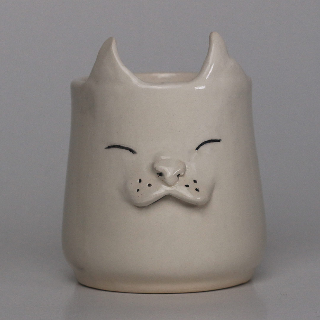 Ceramic mug with raised cat face design