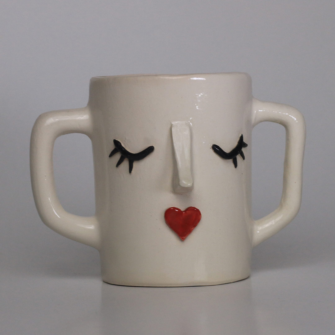 Ceramic mug with relief face design