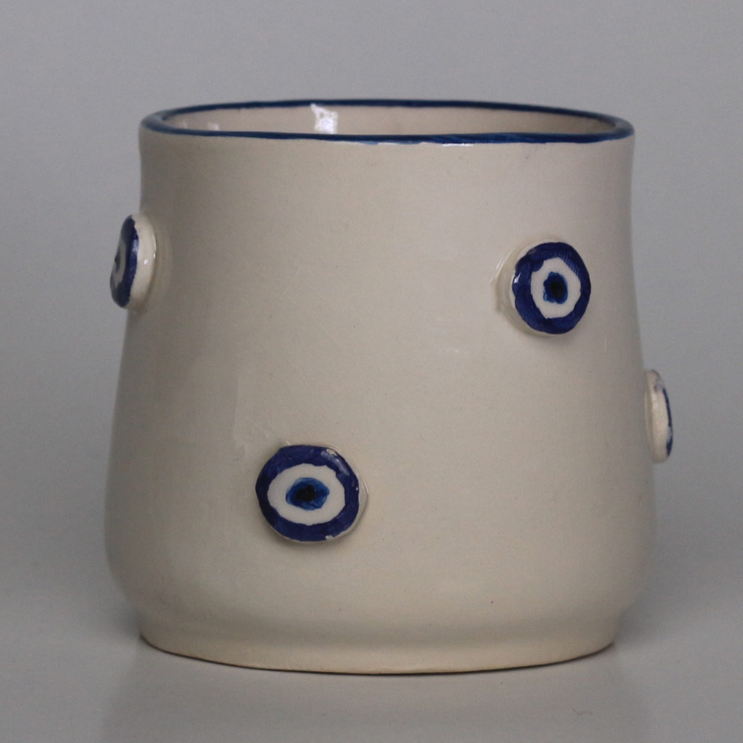 Ceramic mug with small raised eye motif
